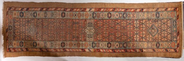 A Serapi runner, the brick red field with all over geometric designs and triple lozenge medallions,