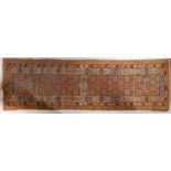 A Serapi runner, the brick red field with all over geometric designs and triple lozenge medallions,