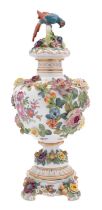 A late Naples Capodimonte flower encrusted jar, cover & stand with parrot finial,