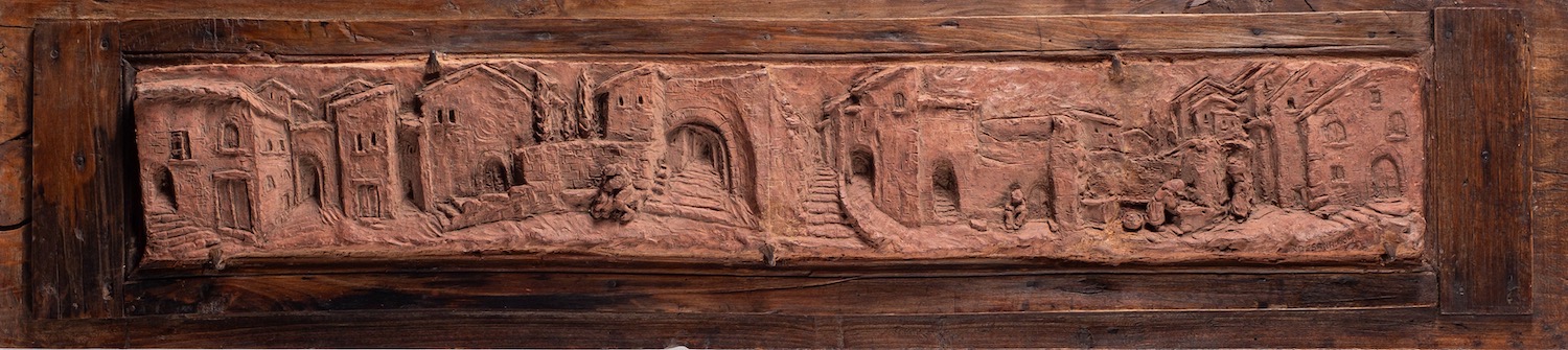 An Italian terracotta plaque, decorated in deep relief with a panoramic view of a village, - Image 2 of 2