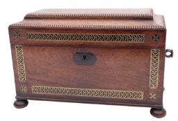 A Regency rosewood and brass inlaid tea caddy, circa 1815; of sarcophagus form,