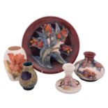 Five pieces of John Moorcroft pottery, comprising a Tulip pattern plate and vase,