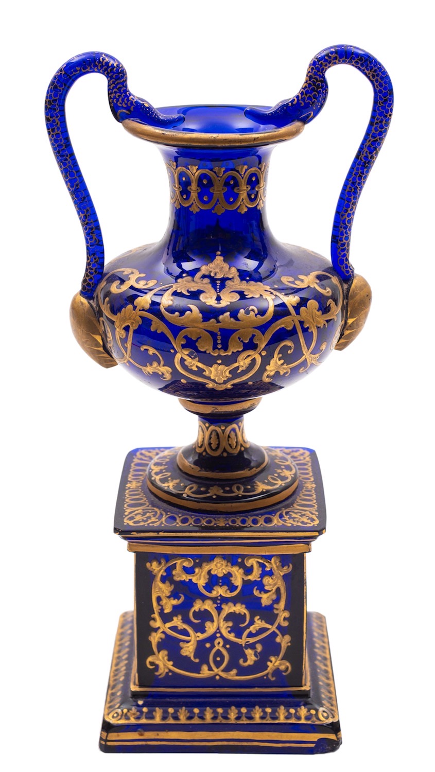 A blue glass and gilt decorated pedestal ewer with serpent handles, 28cm.