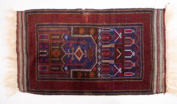 A Belouchistan rug, the indigo geometric field enclosed by a main wine lattice geometric border,