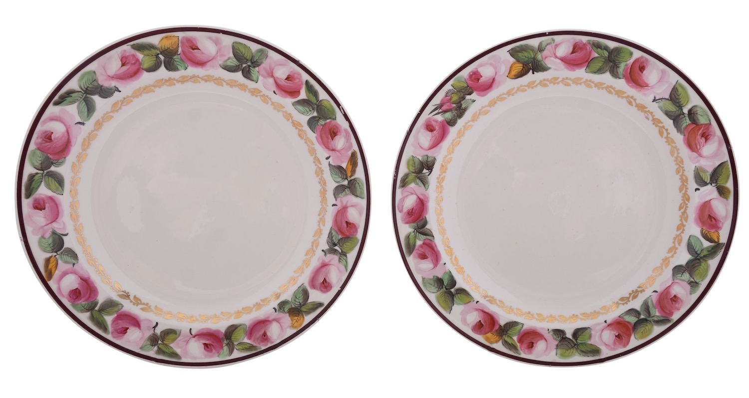 A pair of early 19th century creamware plates the rims painted with pink rose sprays within