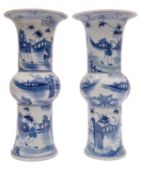 A pair of Chinese 'Gu' form vases, painted in blue with figures in fenced gardens, 20th century,