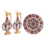 A pair of Royal Crown Derby ewers of flattened pedestal form decorated with an Imari pattern,