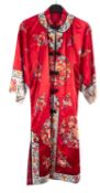 A Chinese hand-embroidered red silk robe, with floral decoration,