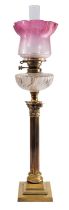 A late Victorian or Edwardian brass and glass mounted columnar table oil lamp,