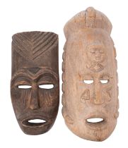 A large African carved wood mask, with a sleeping face carved in relief to the forehead,