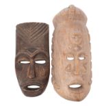 A large African carved wood mask, with a sleeping face carved in relief to the forehead,