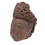 A Chinese carved stone head of Guanyin with serene expression and wearing ornate headress, 35cm.