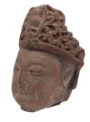 A Chinese carved stone head of Guanyin with serene expression and wearing ornate headress, 35cm.