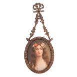 A Continental porcelain oval plaque painted with a head and shoulders portrait of a girl with