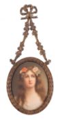 A Continental porcelain oval plaque painted with a head and shoulders portrait of a girl with