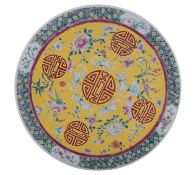 A Chinese yellow-ground famille rose charger painted with shou characters, bats,