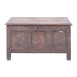 An oak coffer, 17th century with later elements; with hinged cover above a carved front,