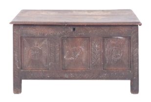 An oak coffer, 17th century with later elements; with hinged cover above a carved front,