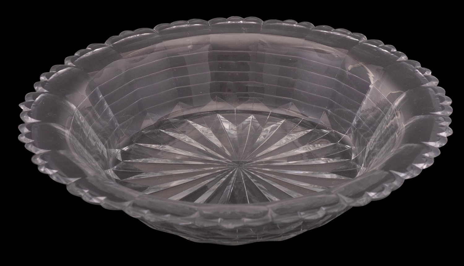 A large early 19th century cut-glass bowl of stepped and fluted form with star-cut base,