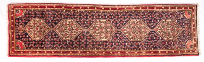 A Senneh runner, the shaded field with a row of five ivory hexagonal medallions,
