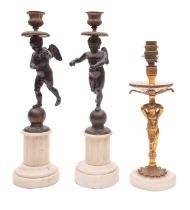 A pair of patinated bronze and marble mounted figural candlesticks,