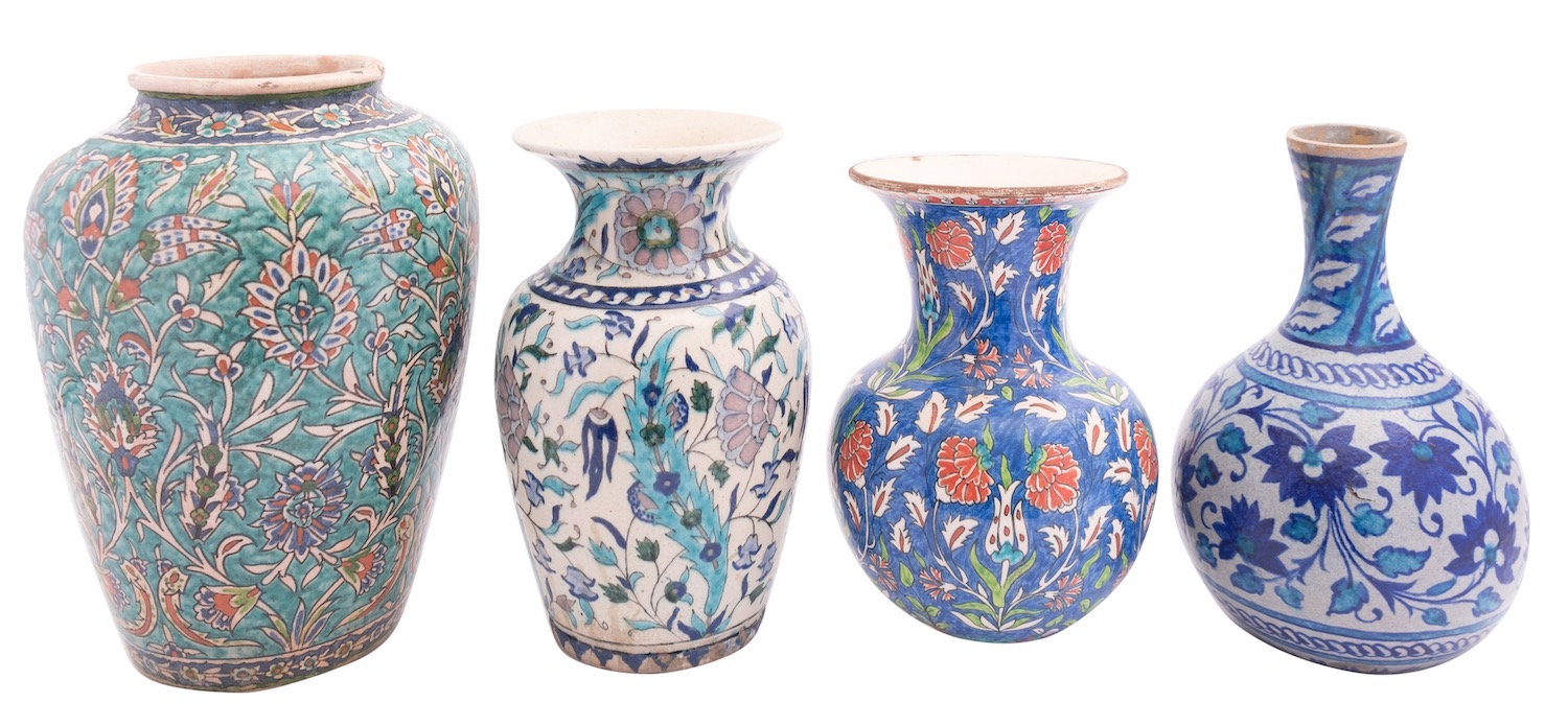 Four Isnik inspired pottery vases, each profusely decorated with flowers and foliage,