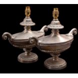 A pair of silver plated metal twin-handled urns fitted as table lamps,