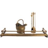 An associated suite of brass fireplace furniture, comprising a fender in 19th century style,
