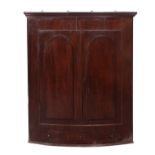 A Regency mahogany bowfront hanging corner cabinet,