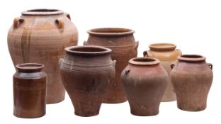 A group of ten stoneware and other earthenware pots, storage jars and a large jug some part glazed,