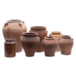 A group of ten stoneware and other earthenware pots, storage jars and a large jug some part glazed,