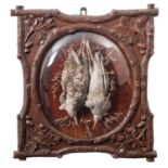 A pair of 'Black Forest' carved and stained oak framed game trophies, Dutch,