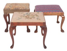 Two carved mahogany and upholstered dressing table stools in George II style,