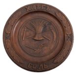 A Russian carved beech bread platter, early 20th century; the tondo with a wheatsheaf, a flail,