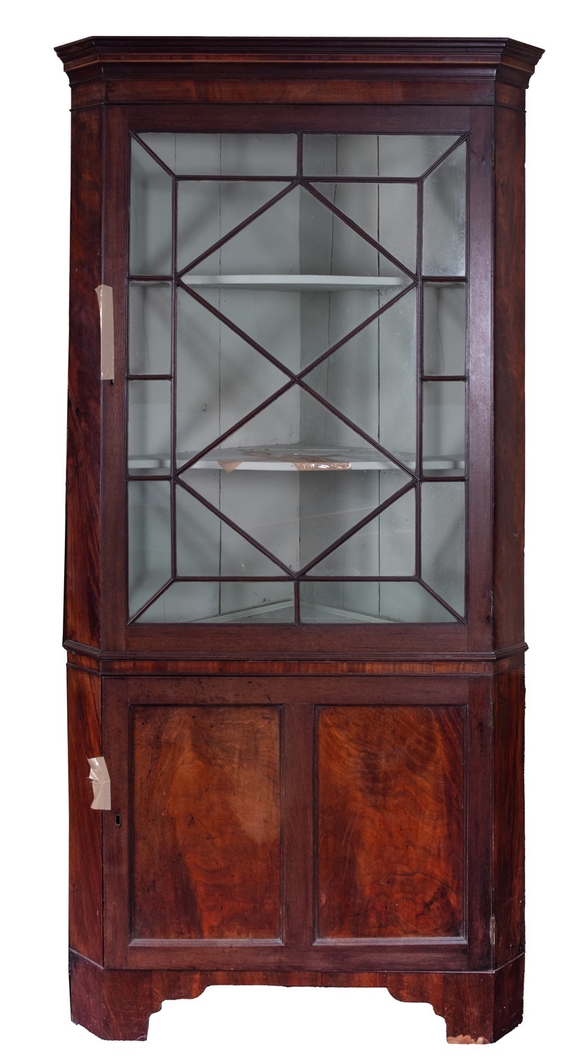 A George III mahogany and glazed corner display cabinet, early 19th century; with moulded cornice,