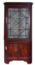 A George III mahogany and glazed corner display cabinet, early 19th century; with moulded cornice,