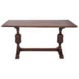 An oak trestle table in Elizabethan style, early 20th century; the rectangular top on twin knopped,