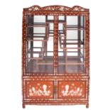 A South East Asian hardwood, mother-of-pearl inset and glazed display cabinet,