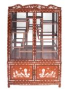A South East Asian hardwood, mother-of-pearl inset and glazed display cabinet,