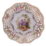 A Dresden pierced plate painted with lovers in a garden vignette within a floral swag border and