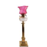 A late Victorian or Edwardian brass and glass mounted columnar table oil lamp,