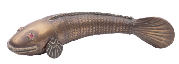An Indian brass articulated fish, early 20th century; with red glass eyes; 17.5cm long.