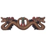 An Indonesian carved and painted wood transom in the form of a double headed serpent, 63cm.