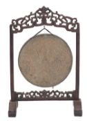A South East Asian hardwood and brass hung gong,