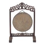 A South East Asian hardwood and brass hung gong,