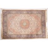 A Kashmir 'silky' rug, the ivory cartouche field with a central brick red circular medallion,