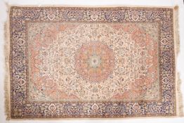 A Kashmir 'silky' rug, the ivory cartouche field with a central brick red circular medallion,