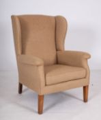 An oatmeal fabric upholstered wing armch