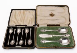 A set of silver coffee spoons and a case