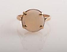 A gold ring set with a circular opal, 9c